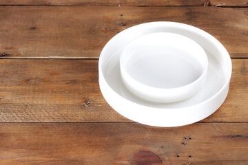 Fototapeta na wymiar Tableware: white empty plate isolated on the wooden table