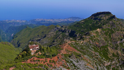 Stunning panorama view of the northeastern coast of Madeira, Portugal with rugged mountains covered by green vegetation and refuge viewed from top of Pico Ruivo (1,862m).
