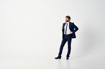 a business man in a classic suit stands in the middle of a room indoors