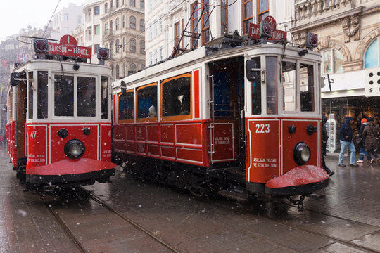 Istanbul, Turkey - January 31, 2012 : Nostalgic tramways were passing by Istiklal Street when snowing at Istanbul Beyoglu. Some people were walking at the street too.