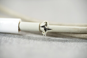 Close up of broken smart phone charger cable on light background