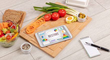 Organic food and tablet pc showing RESTART inscription, healthy nutrition composition