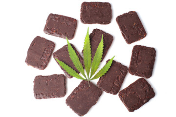 Green hemp or cannabis leaf on white isolated background. Flat lay. Chocolate biscuits with CBD cannabis in a rectangular shape