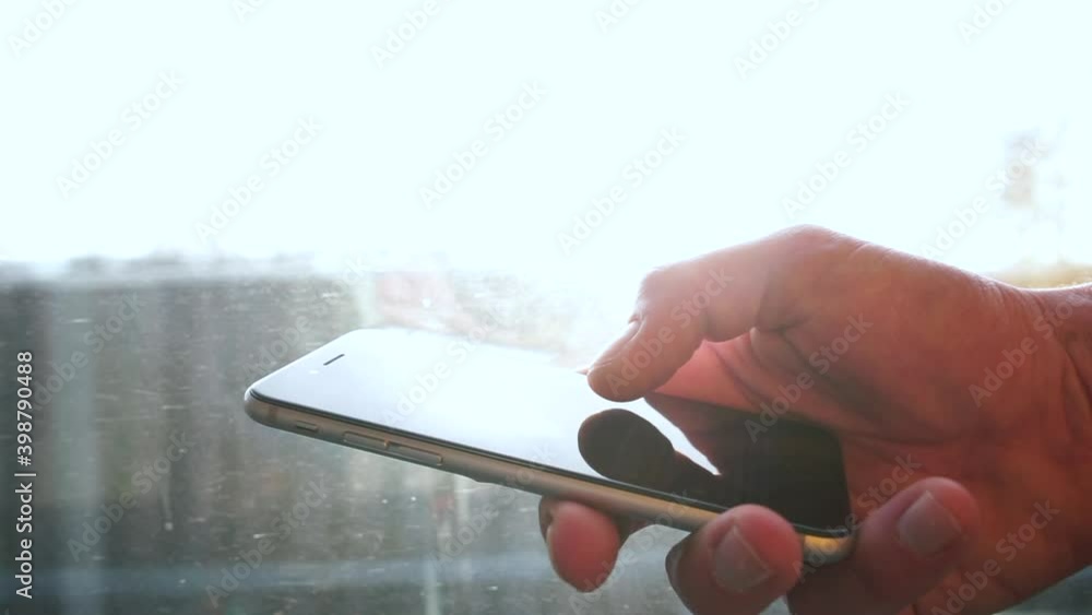 Poster close-up of a hand using a phone in public transport near the window. the finger scrolls. transfer o