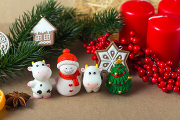 Year of the Bull. Figures of bulls, snowman, ginger cookies, anise seeds, spruce branches, red berries and other New year decorations.