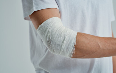 man with bandaged arm elbow and finger injury medicine