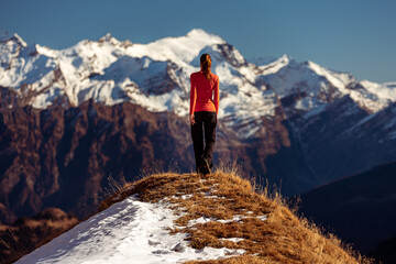 Fototapeta premium woman on top of a mountain observes the view