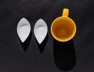 Taza amarilla con agua y dos contenedores para prepara bebida.