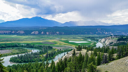 Spectacular view to mountains and fertile green fields along Columbia River in Radium Hot Springs 