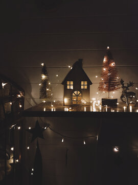 Christmas tree, house, reindeer in festive lights in modern dark room, christmas eve scene