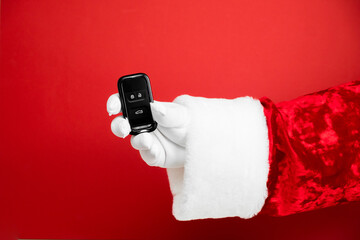 Santa Claus hand holds car keys. Merry Christmas and New Year concept. New car smart key. Buyer,...