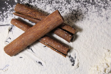 cinnamon sticks against the background of white flour with a copy of the space