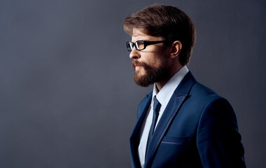 Handsome men in classic suit on a dark background model with glasses cropped view.