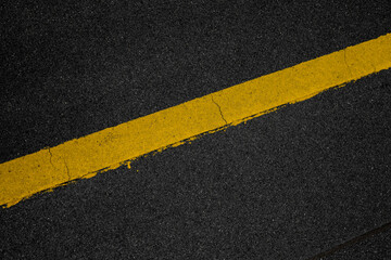 Abstract texture composition in the form of yellow boundary warning lines painted with paint on a dark gray background. The natural texture of the bituminous coating on the roof of the house.