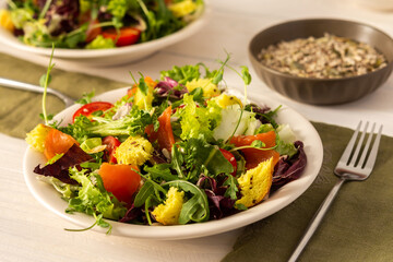 Light breakfast or dinner, mix salad with salmon and different seeds, plate with salad and cornbread close up