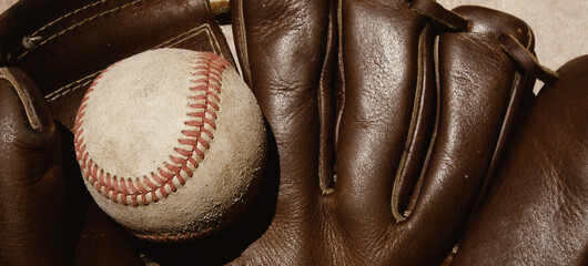 Close up of used baseball in ball glove for sport background of athlete equipment.