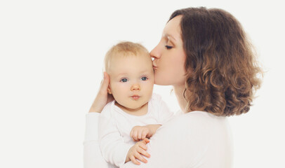 Portrait of happy mother kissing her little baby on a white background