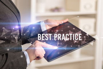 Close up hands using tablet with BEST PRACTICE inscription, modern business technology concept