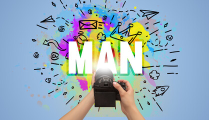 Close-up of a hand holding digital camera with abstract drawing and MAN inscription