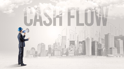 Fototapeta premium Young businessman with hard hat and CASH FLOW inscription, new business opportunity concept