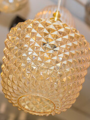 One switched-off ceiling chandelier made of yellow glass is suspended from the ceiling. Concept of...