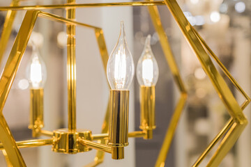 Luminous ceiling chandelier made of gold metal with transparent glass lamps in the form of candles....