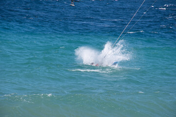 Obraz premium Hombre cae al agua mientras hacía windsurf