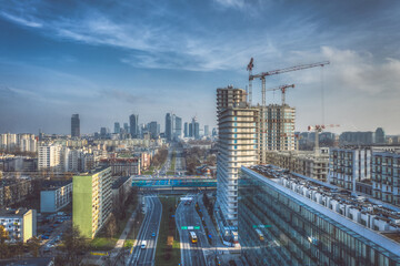Housing project construction site and Warsaw distant city center aerial view