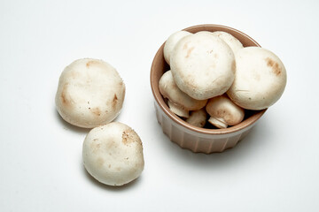 White mushrooms champignons on a light background.