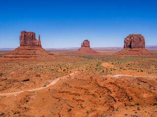 Panoramic view of Monument Valley, Utah, USA during a hot sunny day with the view of  West Mitten Butte, East Mitten Butte and Merrick Butte