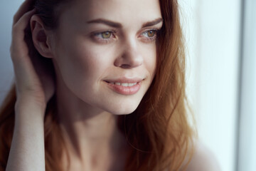 Obraz premium pretty smiling woman near window at home morning rest