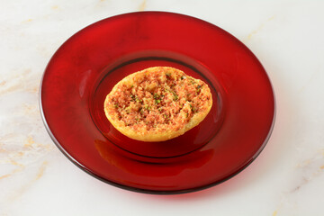Tomato and oregano bruschetta snack on red glass plate on table