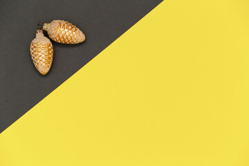 Christmas composition in colors of the 2021 year Illuminating and gray. Christmas gold pine cones on gray and yellow background.