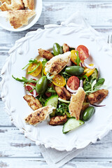 Healthy Salad with Chicken Breast, Cherry Tomatoes, Cucumber, Rocket and Green Olives. Top view. 