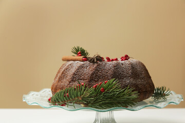 Festive decorated bundt cake with red berries on the light ochre background.	