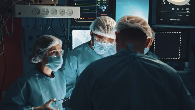 Attentive medical workers operating their patient. Motion camera view of the serious surgeons discussing case with patient before the performing serious operation in hospital with modern equipment