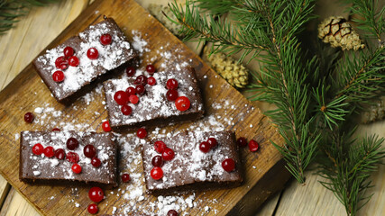 Christmas chocolate cakes with cranberries and powdered sugar. Good New Year spirit.