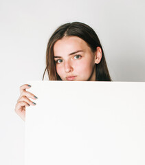 young pretty brunette girl with placard shit copyspace on white background wearing business costume student