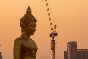 Fototapeta na wymiar Giant Golden Buddha Image Under Construction at Wat Paknam Phra Sri Charoen Temple.