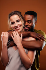 young pretty couple diverse races together posing sensitive on brown background, lifestyle people concept