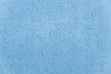 small and large drops of condensation on frosted colored glass