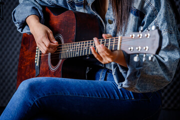 Obraz premium Close up woman fingers holding mediator with a Guitar recording a song in recording studio