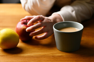 Young wooman drinking hot cocoa or coffee. Autumn or winter moody weekend, New Year and Christmas background. Lazy day, quarantine, stay home, cosy scene, hygge concept.