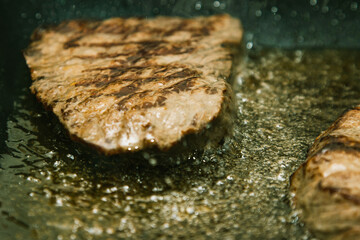 Beef steaks Sizzling in a pan of boiling oil.