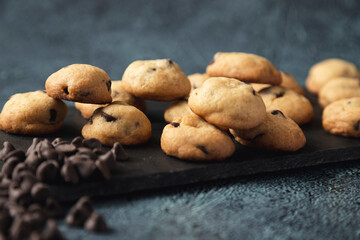 Mini chocolate chip cookies served on an elegant black plate - gourmet snacks - fine pastries