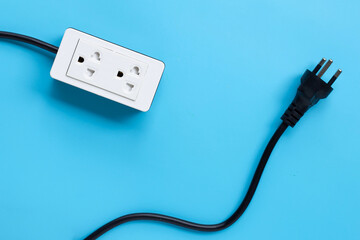 Electrical power strip and plug on blue background. Top view