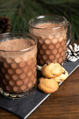 Elegant mugs with hot chocolate and mini chip cookies - hot chocolate served on the christmas table - christmas content - christmas traditions