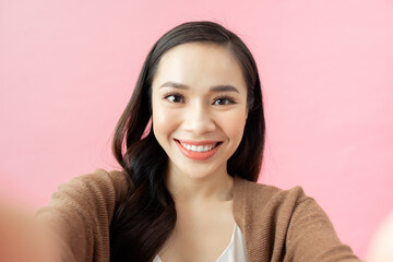 Fototapeta premium Woman making selfie. pink background