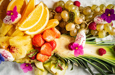 Obraz na płótnie Canvas fresh fruit and berries with edible flowers