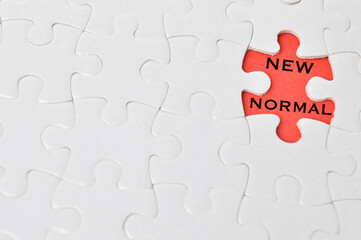 The words NEW NORMAL in missing piece jigsaw puzzle. Business  and Education concept. 